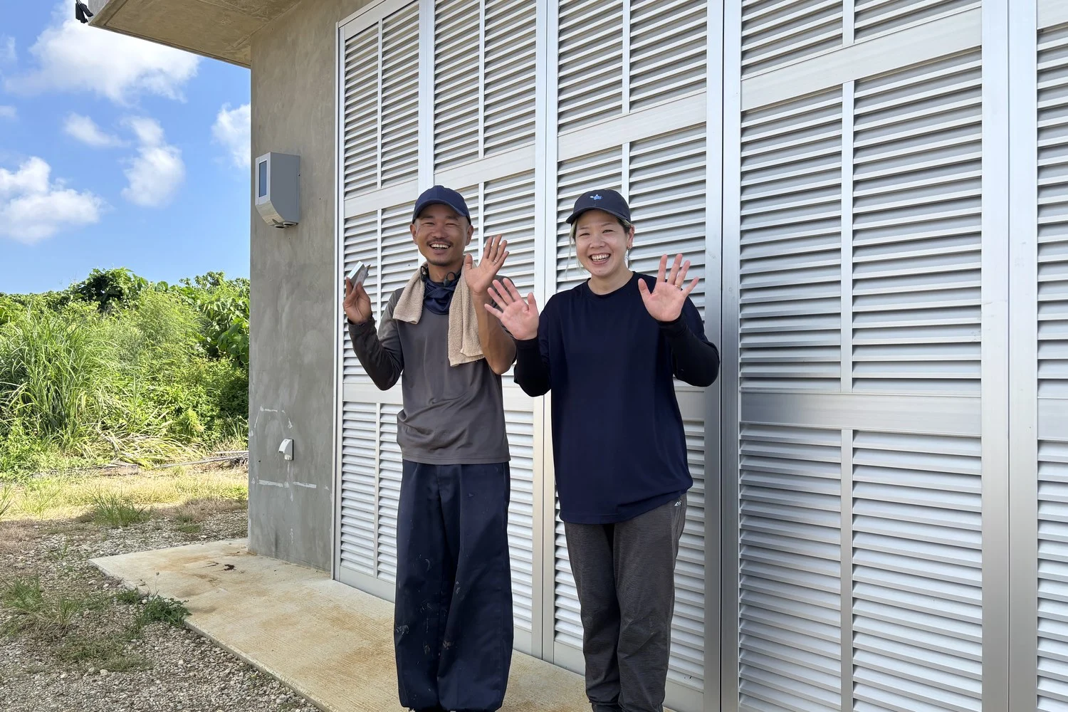 建物の前で手を振るご夫妻