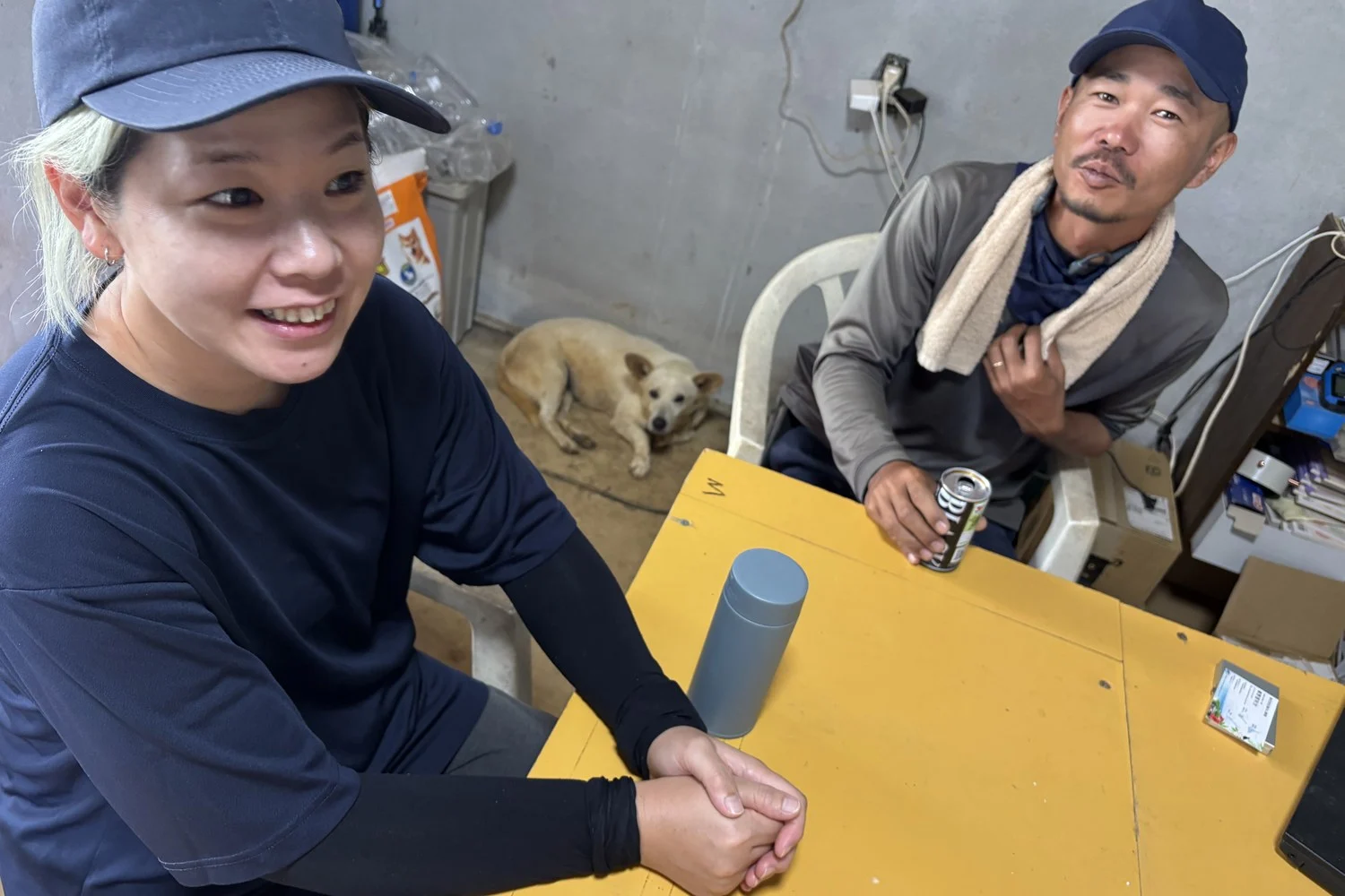 笑いながら話すご夫妻と、足元にいる犬
