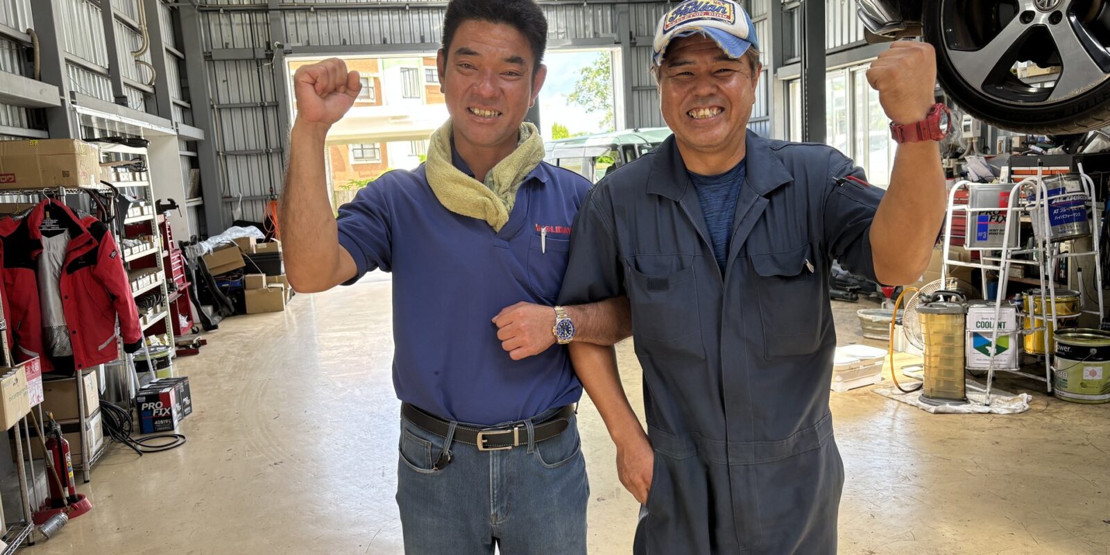 整備工場で並んで立つ2人