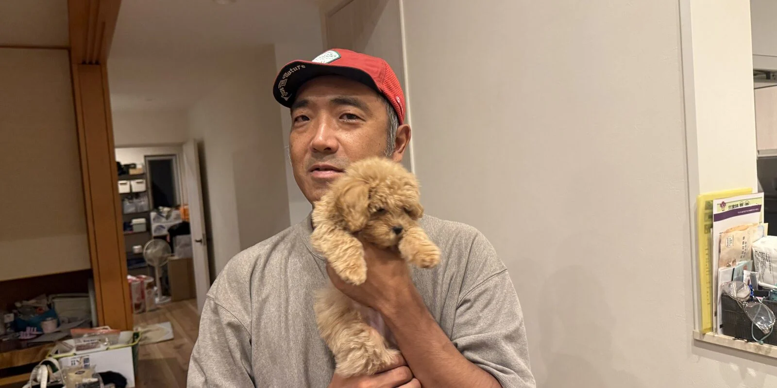 子犬を抱いて笑う男性