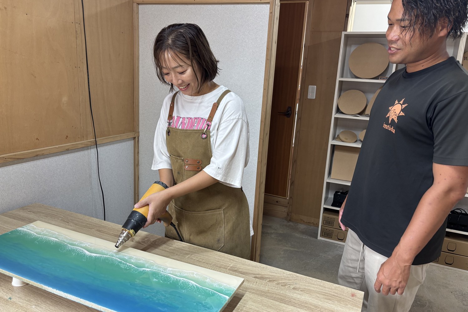 ヒートガンを使うスタッフと、隣で見ている徳永さん