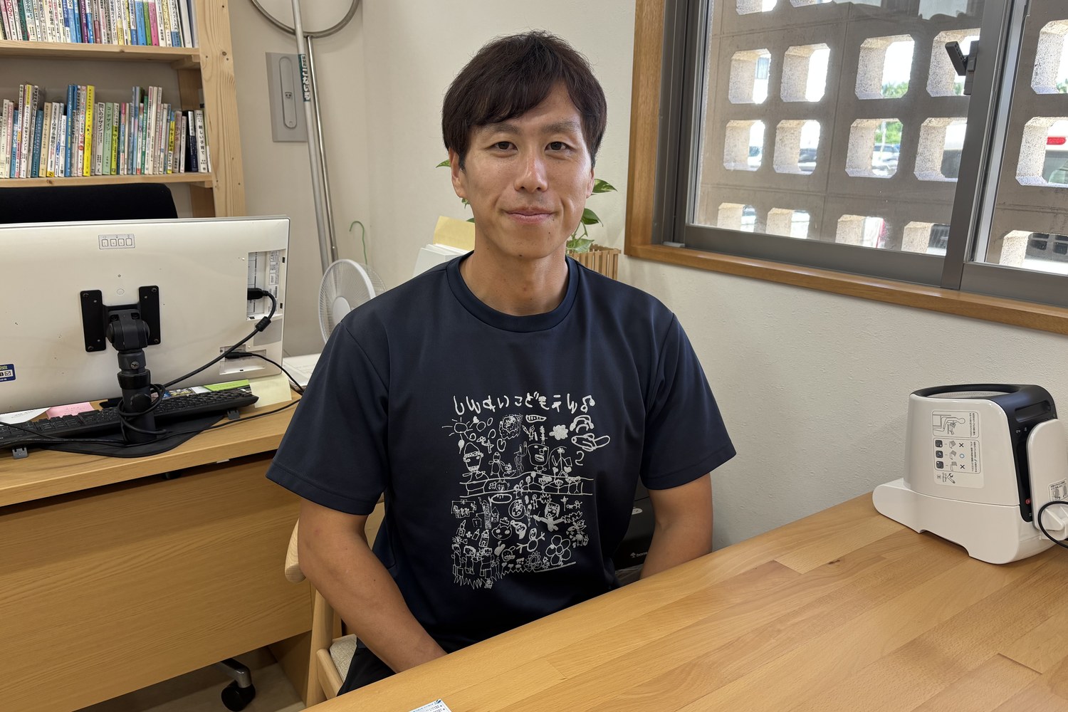 事務室で話す荒巻さん