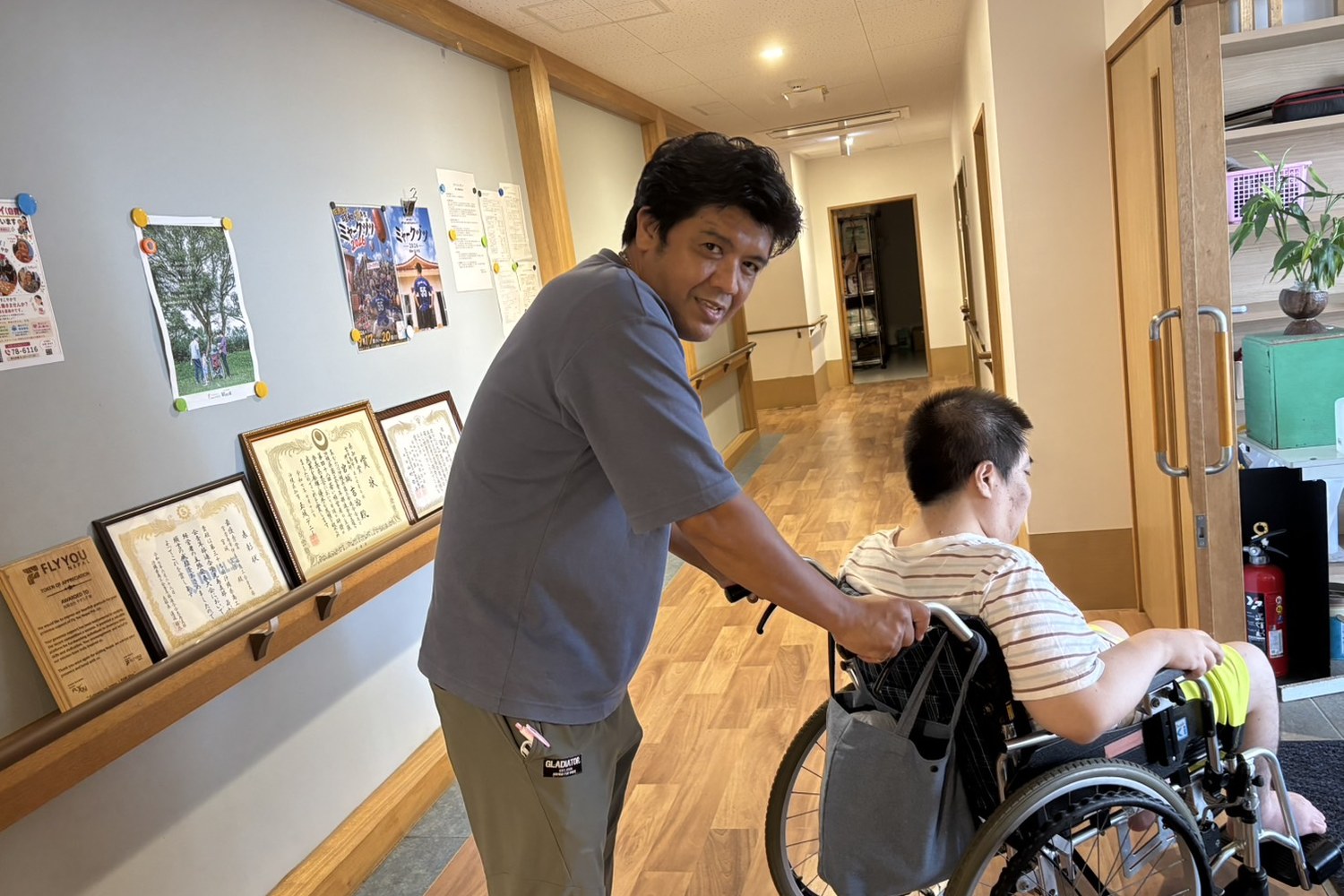 施設の廊下で車いすを押すところ