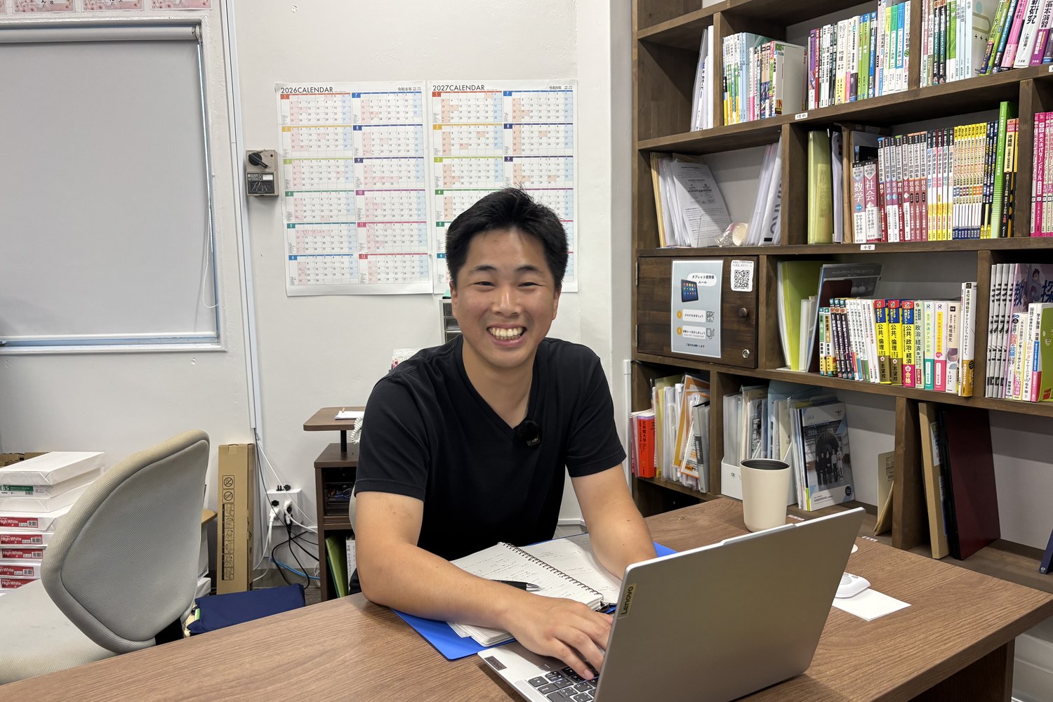デスクに座って笑う牧野さん