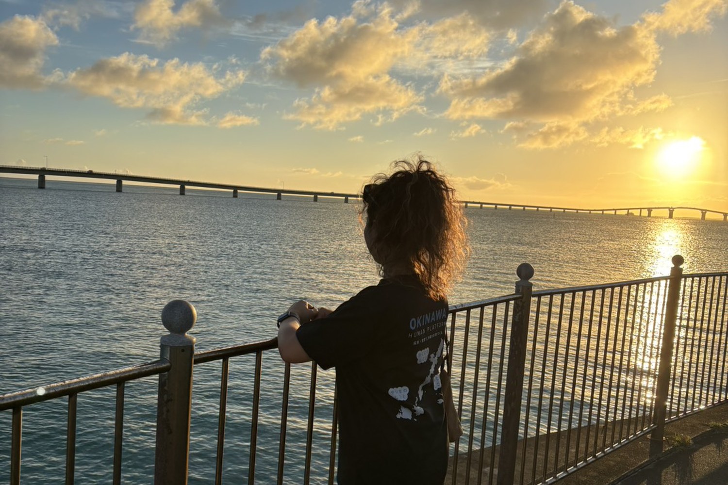 夕暮れの海と橋を眺める槙野さん