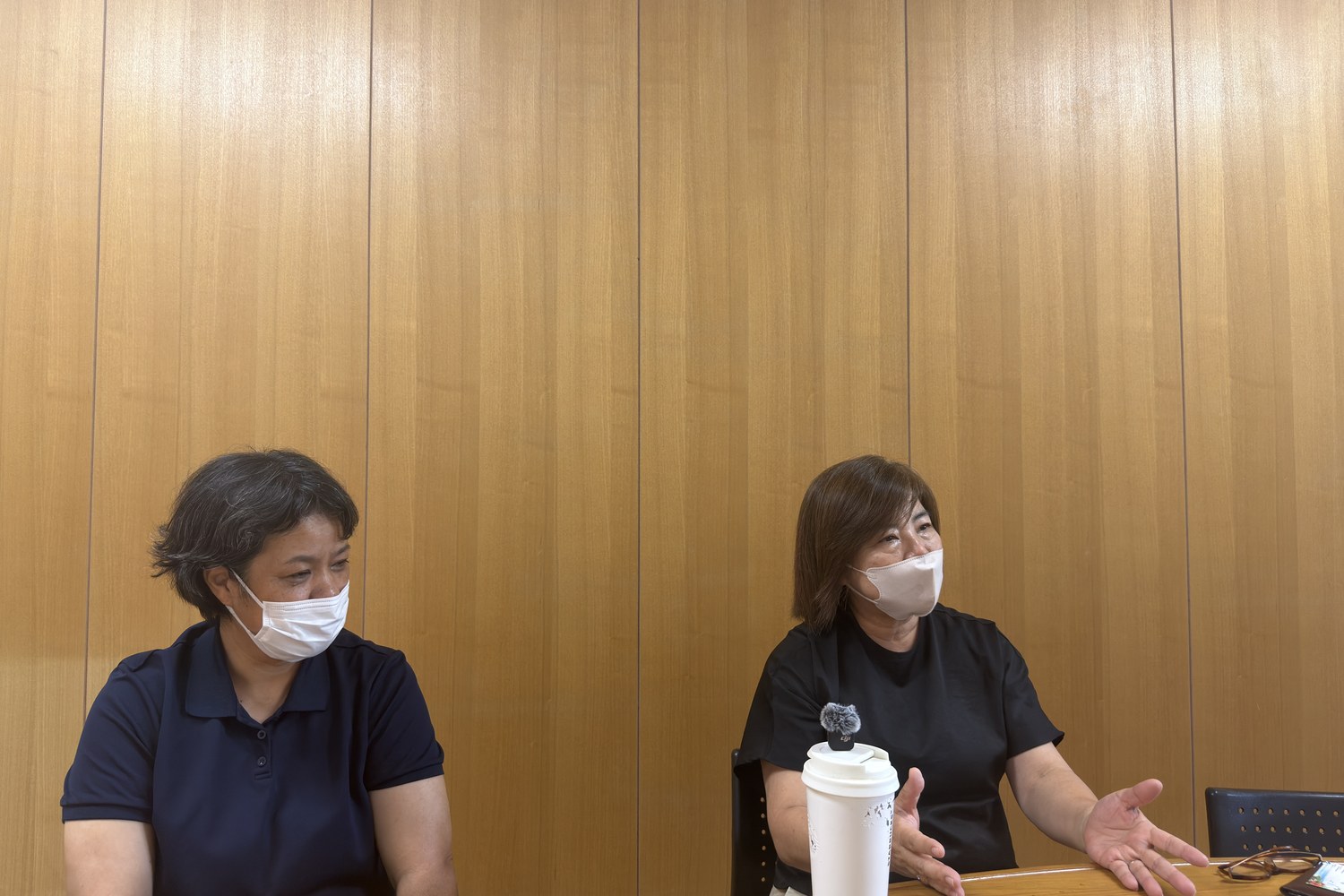 机をはさんで話すお二人