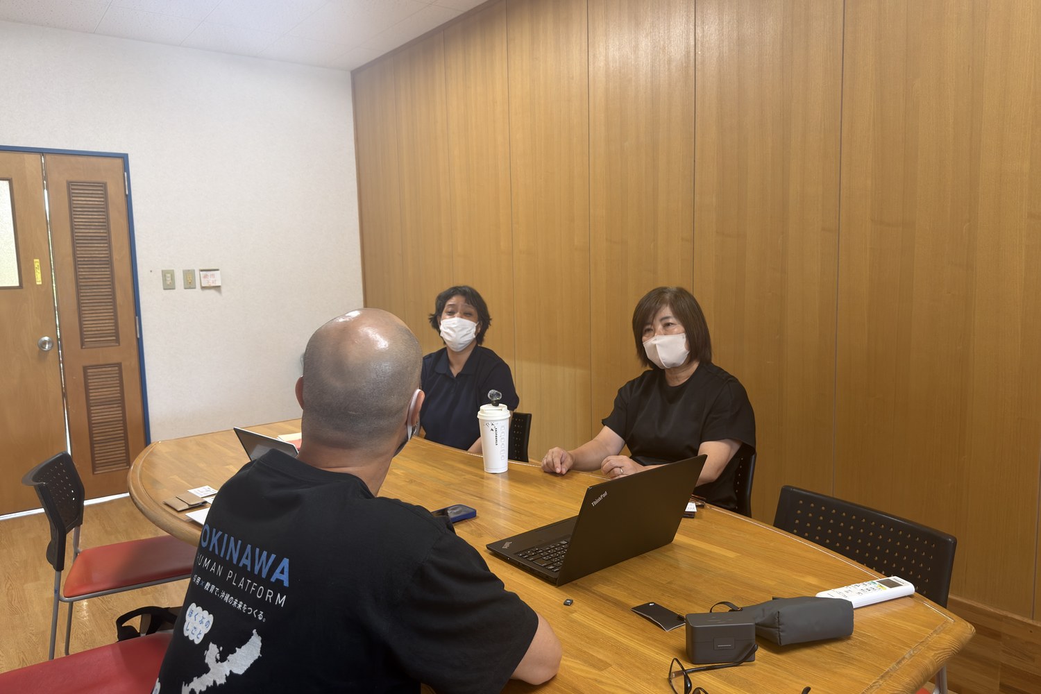 机を囲んで取材をしている場面