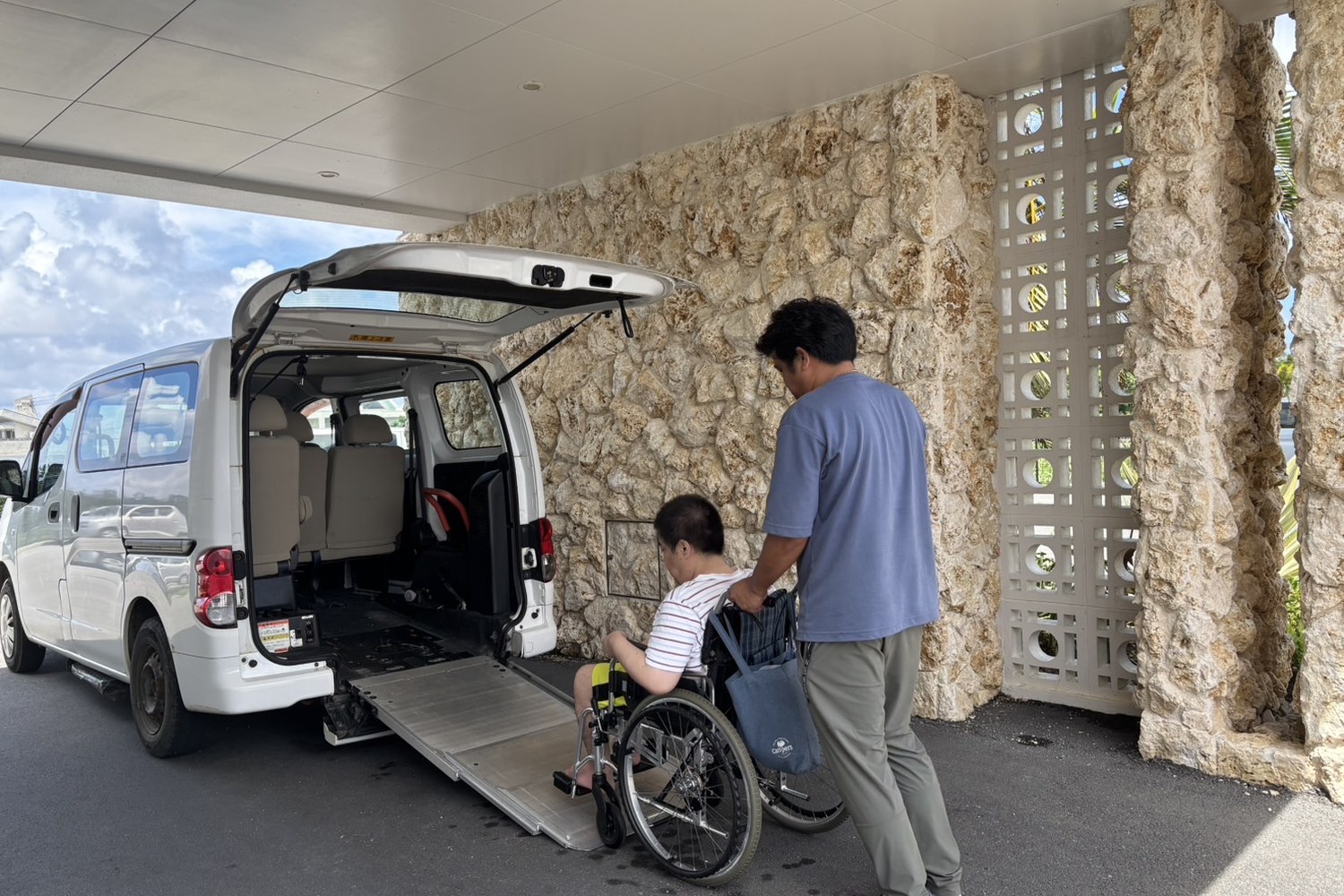 車の後ろで車いすの乗り降りを介助する加藤さん