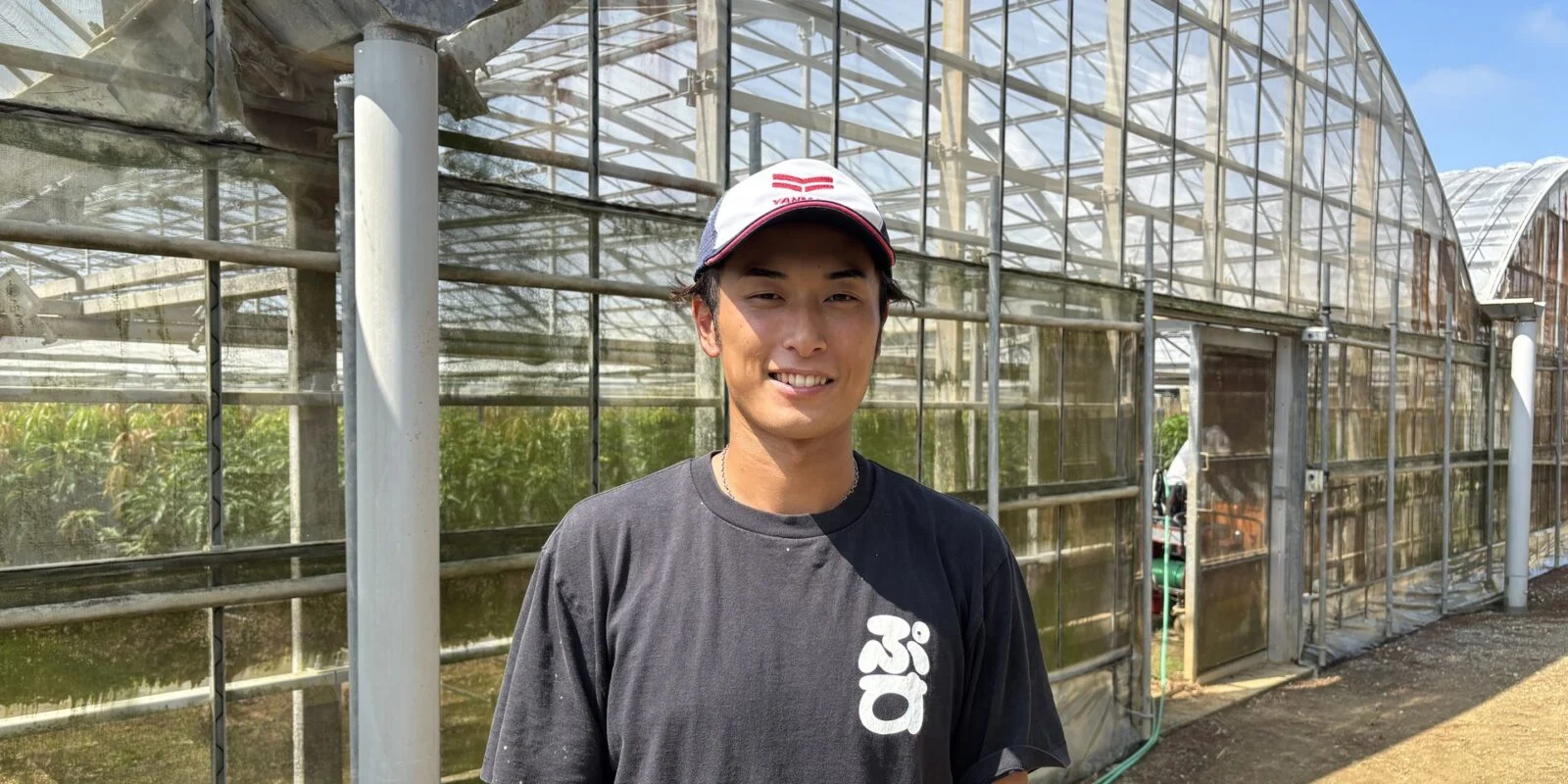 マンゴーのハウスの前に立つ角田さん