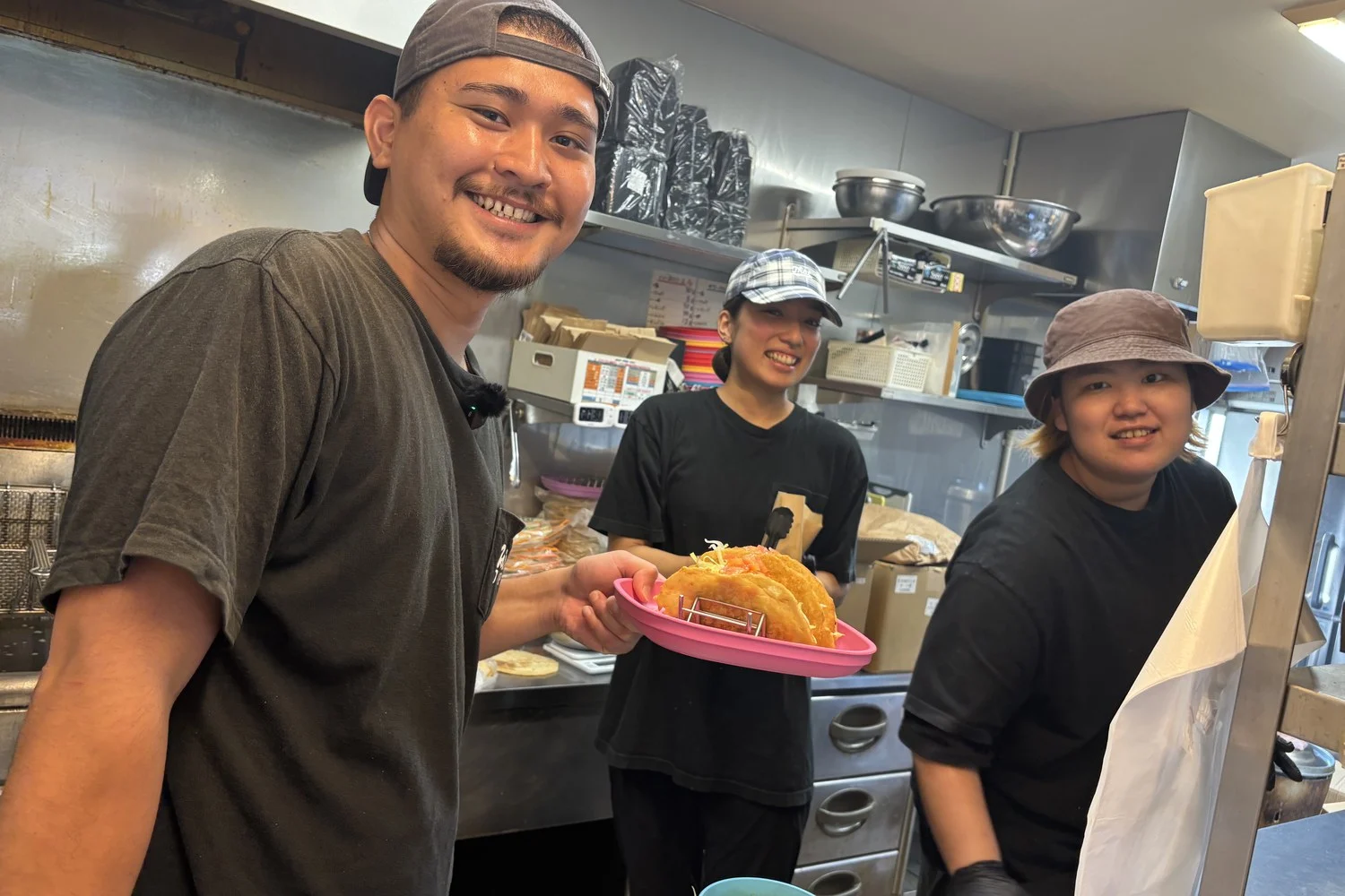 できあがった料理を手にする赤嶺さんと、厨房のスタッフ