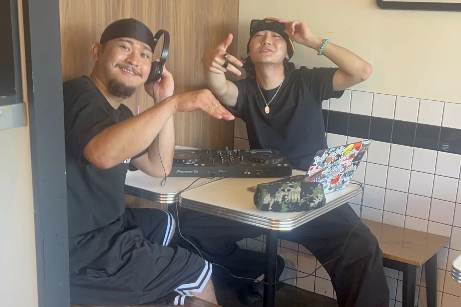 DJ機材を前にした赤嶺さん（左）とスタッフ